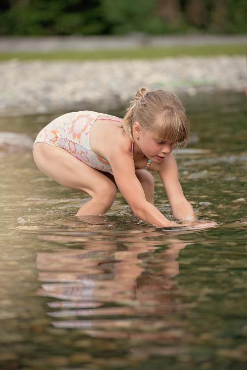 在水中抓鱼的小女孩