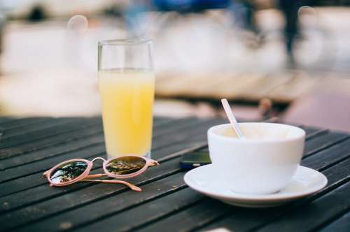 一杯咖啡与橙汁和眼镜