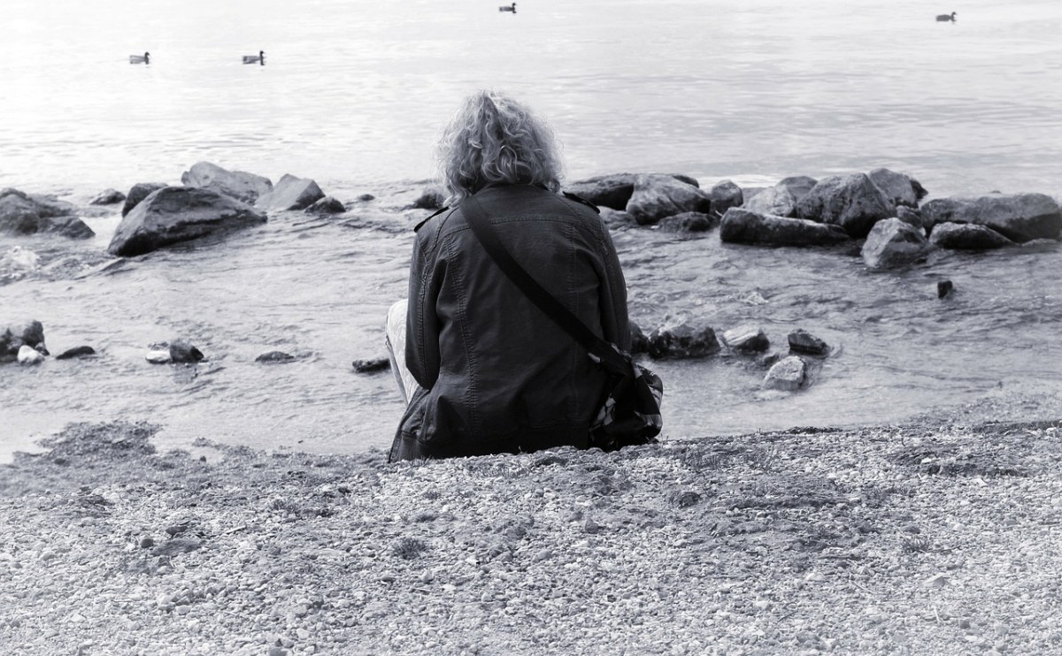 坐在海边的孤独人物背影免费图片