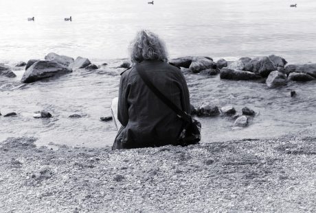 坐在海边的孤独人物背影