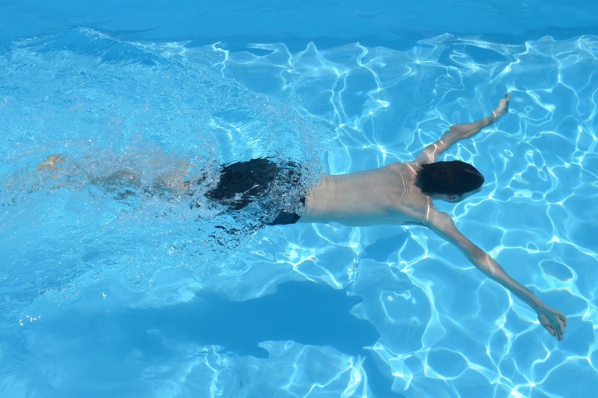 游泳池中游泳的男子免费图片
