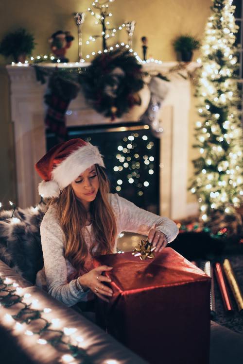 戴着圣诞帽打开圣诞礼物的女生图片