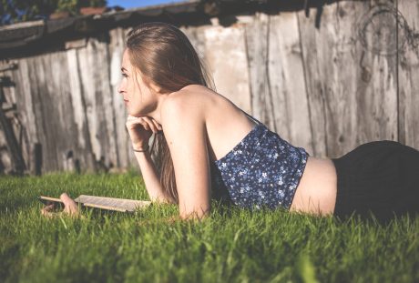 趴在草地上看书的美女阅读人物