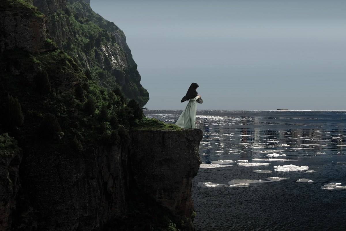 站在海岸悬崖上的孤独女性人物免费图片