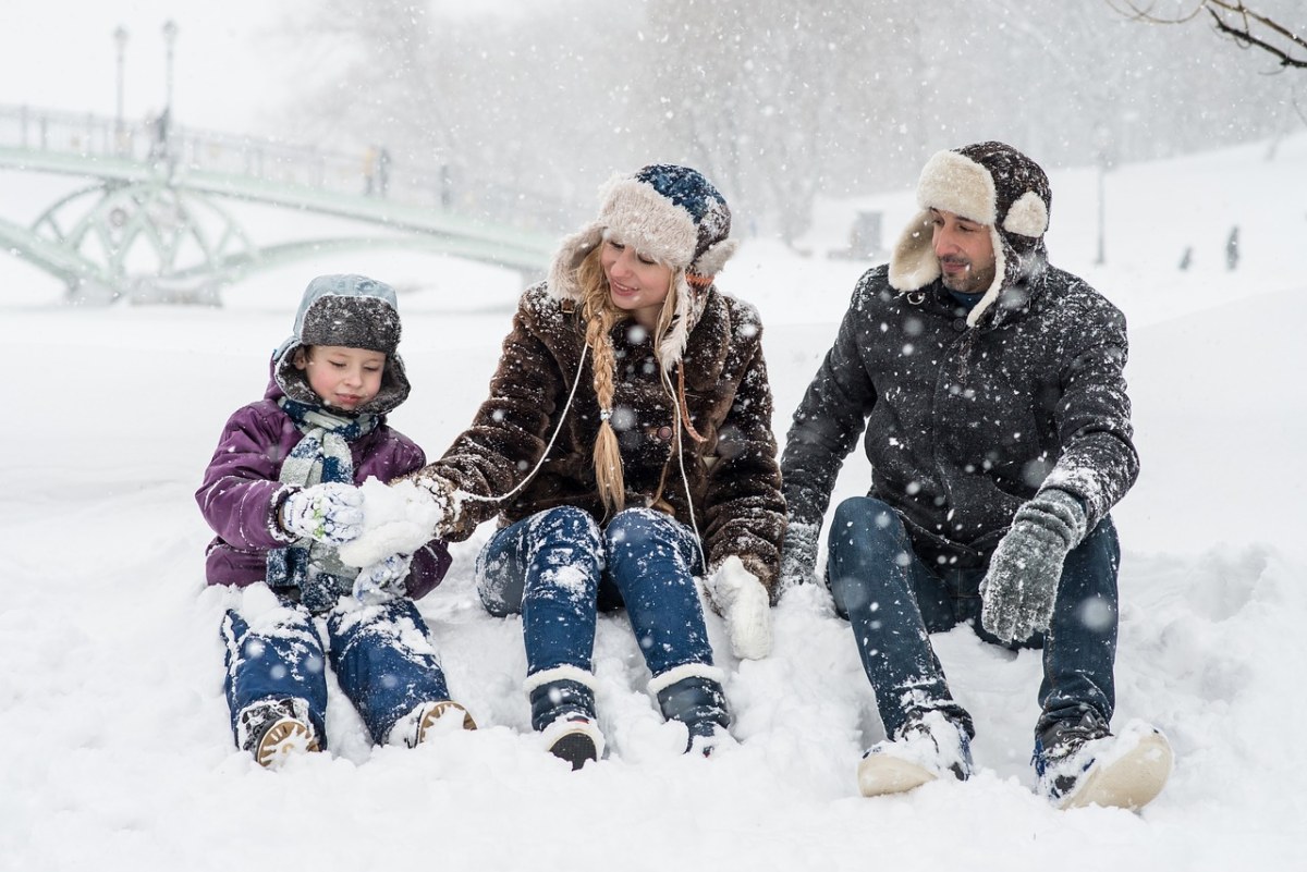坐在雪地上的一家三口免费图片