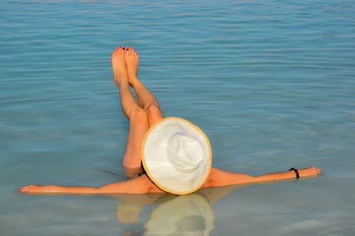戴着草帽躺在水面上的女人