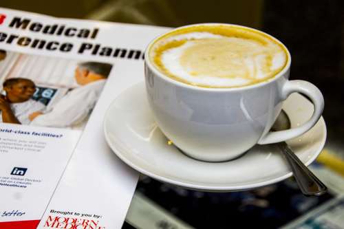 一杯咖啡与英文新闻报纸的图片