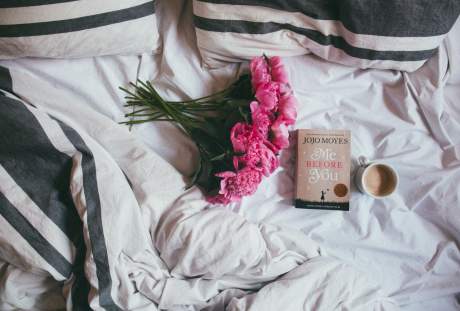 床上的花束、书籍与咖啡的静物图片