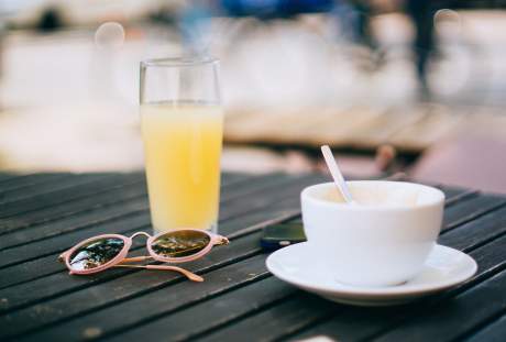 一杯咖啡与橙汁和眼镜