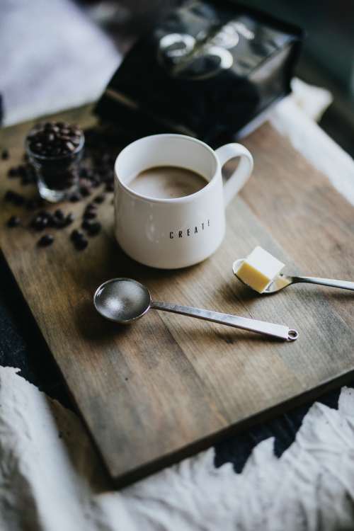 木板上的咖啡与不锈钢勺子